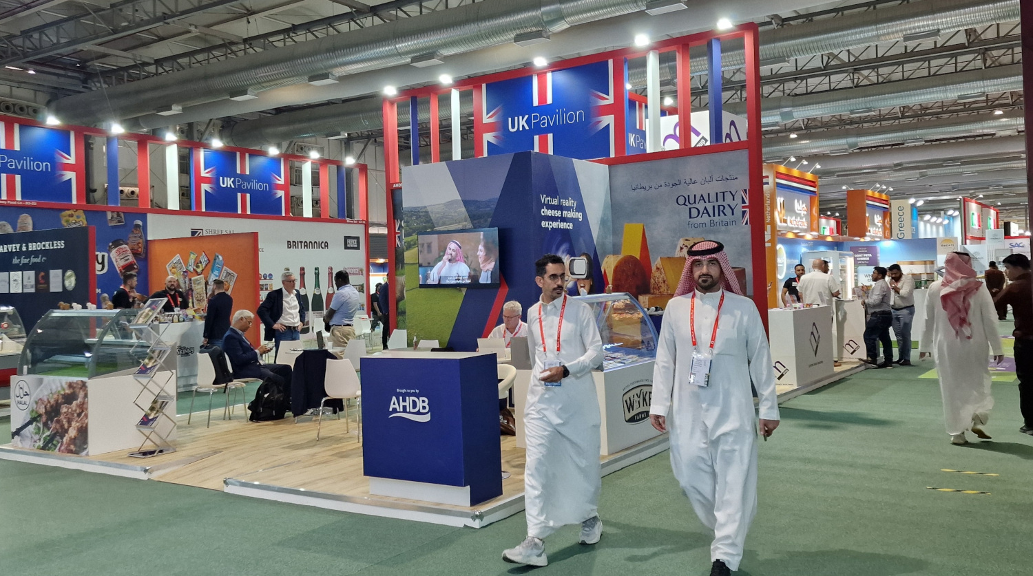 Two people walking past the UK pavilion at the Saudi Arabia trade show.
